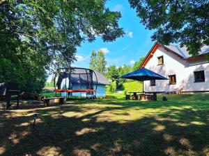a house with a picnic table and a blue umbrella at Chalupa Petra in Dolní Morava