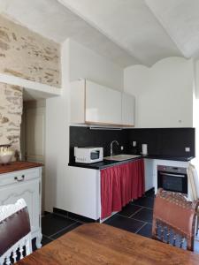 格霍皮耶的住宿－Chambres chez l habitant près de Vallon pont d Arc，厨房配有白色橱柜和带微波炉的台面。