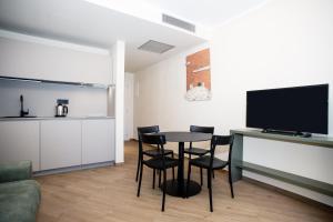 a living room with a table and chairs and a tv at Hotel Barcarola 2 in Marina di Campo