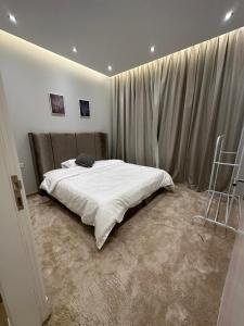 a bedroom with a large white bed and curtains at الماجدية 53 ( A3) in Riyadh