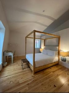 a bedroom with a canopy bed and a desk at Palácio do Visconde - The Coffee Experience in Lisbon