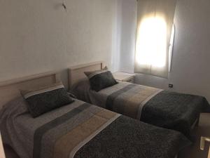 2 camas en una habitación de hotel con ventana en Villa haut standing Mdiq Fnideq Bahia Smir, en Dar Merah Deriba