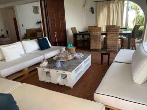 una sala de estar con sofás blancos y una mesa. en Villa haut standing Mdiq Fnideq Bahia Smir, en Dar Merah Deriba
