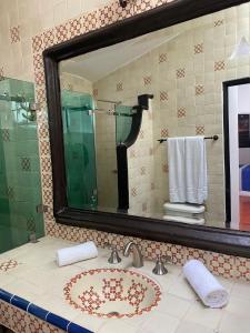 een badkamer met een wastafel en een spiegel bij Casa Yollotzin in Ajijic
