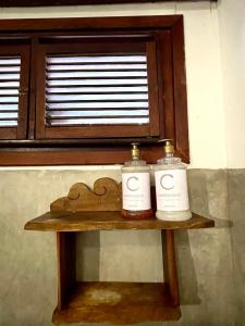 two bottles on a wooden table in front of a window at Controvento Boutique Hotel in Cumbuco