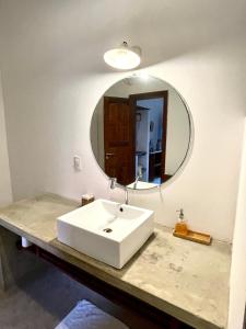 La salle de bains est pourvue d'un lavabo blanc et d'un miroir. dans l'établissement Controvento Boutique Hotel, à Cumbuco