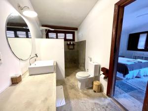 a bathroom with a toilet and a sink and a mirror at Controvento Boutique Hotel in Cumbuco