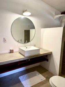 een badkamer met een witte wastafel en een spiegel bij Controvento Boutique Hotel in Cumbuco