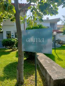 a sign that says calima next to a tree at Calma Resort in Skála Foúrkas