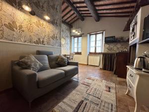 Il comprend un salon avec un canapé et une cuisine. dans l'établissement La soffitta nel Bastione, à Pitigliano