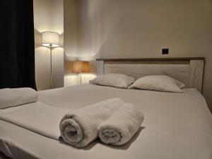 ein weißes Bett mit Handtüchern darüber in der Unterkunft Lemon Tree Inn in Markopoulo