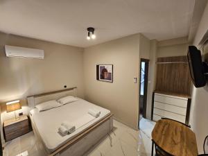 Un dormitorio con una cama y un televisor en una habitación. en Lemon Tree Inn, en Markopoulo