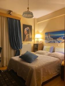 a bedroom with two beds and a painting on the wall at Πηνελόπη Apartment 3-bed flat in Tripolis