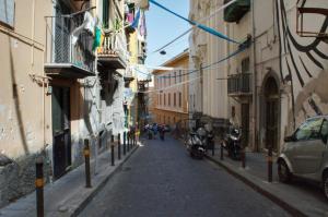 eine schmale Straße mit Gebäuden und einem Auto auf der Seite in der Unterkunft Casa Angelina in Neapel
