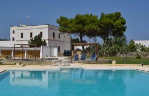 a large swimming pool in front of a house at Masseria Bosco Mazza in Melendugno