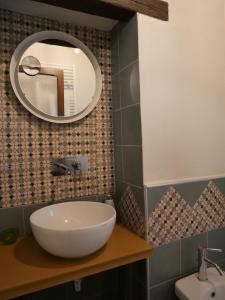 La salle de bains est pourvue d'un lavabo et d'un miroir mural. dans l'établissement La soffitta nel Bastione, à Pitigliano