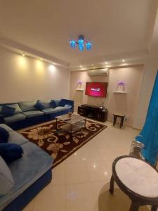 sala de estar con sofá azul y TV en شقق سكنيه للايجار en El Cairo