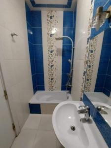 y baño azul y blanco con lavabo y ducha. en شقق سكنيه للايجار en El Cairo