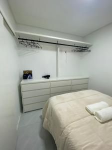 a white bedroom with a bed and a white wall at Apartamento Aconchegante e Silencioso em Bairro Tranquilo in Bento Gonçalves