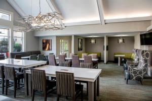 a restaurant with tables and chairs in a room at Residence Inn Cincinnati Airport in Erlanger