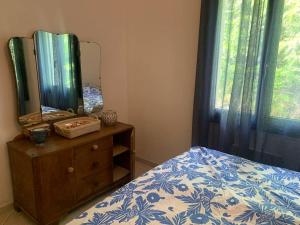 een slaapkamer met een bed en een spiegel op een dressoir bij Ferienhaus mit grandiosem Blick in Anduze