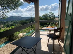 een tafel en stoelen op een balkon met uitzicht bij Ferienhaus mit grandiosem Blick in Anduze