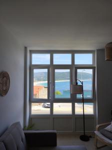 a living room with a window with a view of the ocean at Apartamento AREAL in Fisterra