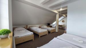 Habitación con 3 camas en una habitación en Willa Centrum, en Supraśl