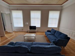 a living room with a blue couch and a table at Home Inn MRT19 in Stockholm