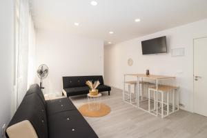 sala de estar con sofá negro y mesa en Amplio y bonito apartamento en La Maruca, en Santander