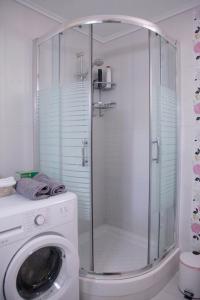 a shower in a bathroom with a washing machine at Sea Front Retreat in Kavala