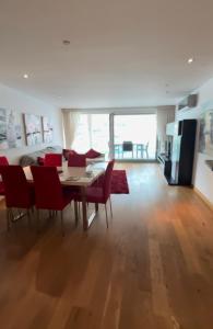 ジブラルタルにあるOcean Village Luxury 2 Bed 2 Bath Apartment - amazing views - pools and jacuzzisのダイニングルーム(テーブル、赤い椅子付)