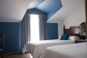 Hotel Cueli في Viveda: غرفة نوم بسريرين وسقف ازرق