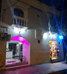una tienda con luces rosas en el lateral de un edificio en Hotel Bahia Suite, en Santa Marta