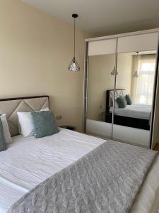 ein Schlafzimmer mit einem Bett und einem großen Spiegel in der Unterkunft Апартаменты CLASSIC в жк Империал in Truskawez