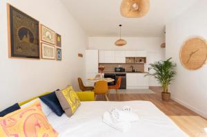 Cet appartement comprend une chambre avec un lit blanc et une cuisine. dans l'établissement {La petite Casà de Cézar} * Centre ville Marseille * Clim, à Marseille