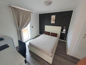 1 dormitorio con cama, escritorio y ventana en Guest House Brezza Marina, en Fiumicino