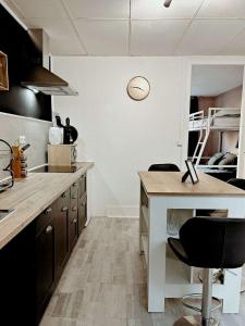 una cocina con encimera y algunas sillas. en Bel appartement sur Dunkerque, en Dunkerque