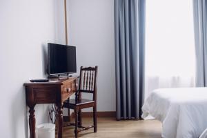a bedroom with a desk with a tv and a bed at Hotel Cueli in Viveda