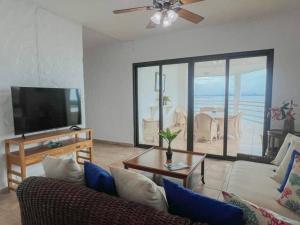 a living room with a couch and a flat screen tv at Live an adventure in Taboga 2 in Taboga