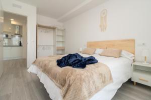 a bedroom with a large bed with a blue blanket on it at REFUGIO DEL PESCADOR Apartamento Maruca in Santander