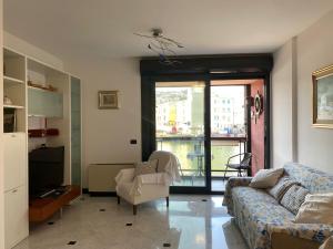 uma sala de estar com um sofá, uma televisão e uma janela em APPARTAMENTO SUL MARE KATE em Gênova