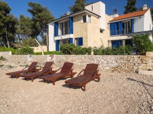 a row of chairs sitting in front of a building at Villas Violet & Rosemary in Supetar