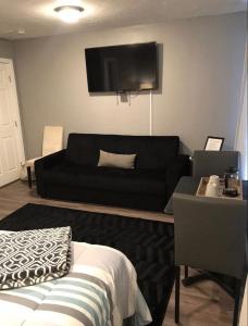 sala de estar con sofá negro y TV de pantalla plana en Studio Gaslamp Conv Cntr - W Parking & 2 Beds #4, en San Diego