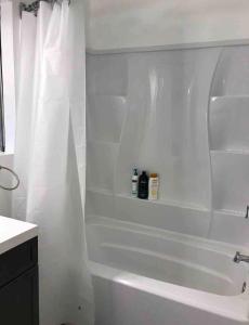a bathroom with a white tub and a white shower curtain at Studio Gaslamp Conv Cntr - W Parking & 2 Beds #4 in San Diego