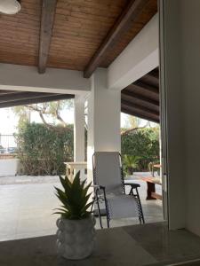 a patio with a chair and a plant on a table at Passalacqua House in Cinisi