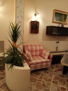 een woonkamer met een stoel en een plant bij Da Giusy le petit bijou in Castelbuono