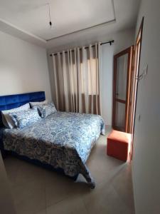 Un dormitorio con una cama azul y una ventana en Lilac's Garden vue piscine en M'diq