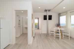 Habitación blanca con mesa, sillas y baño. en Precioso apartamento con vistas espectaculares, en Santander