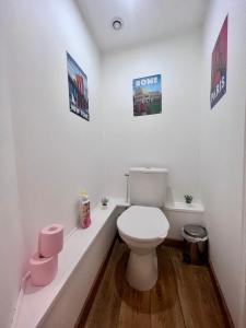 baño con aseo y carteles en la pared en Casa Montcalm - Spacieux - Brive Proche Gare/Centre, en Brive-la-Gaillarde